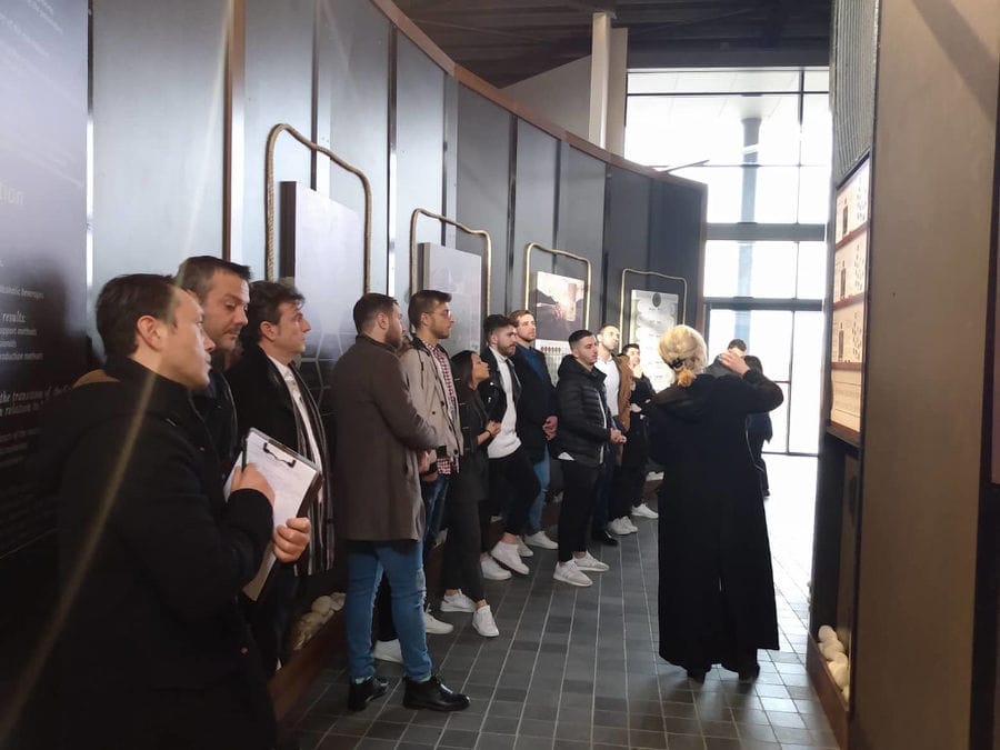 tourists listening to a woman giving a tour at 'Dorodouli Tsipouro'